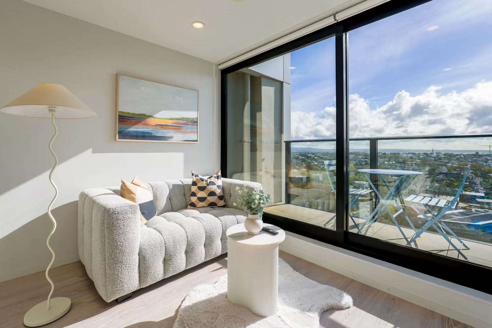 Bright apartment living room with floor-to-ceiling windows and a balcony.